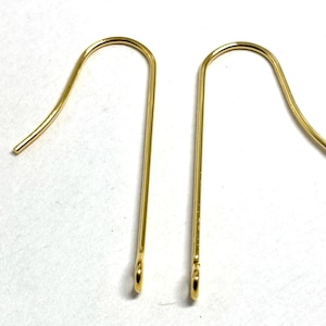 May include: Two gold-colored earring hooks. The hooks are made of metal and have a simple, elegant design.