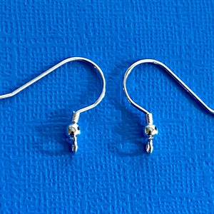 May include: Two silver earring hooks with a small ball at the end of each hook.