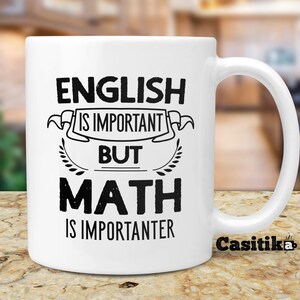 May include: White ceramic coffee mug with black text that reads "English is important but math is importanter".