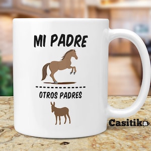May include: White ceramic mug with a brown horse illustration and the text "MI PADRE" above a dashed line and the text "OTROS PADRES" below the line. A brown donkey illustration is below the text. The mug has a black text logo "Casitika" on the bottom right.