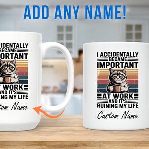 K&ouml;nnte beinhalten: Wei&szlig;e Keramik-Tasse mit Henkel, mit einer Katzenillustration und dem Text "I ACCIDENTALLY BECAME IMPORTANT AT WORK AND IT'S RUINING MY LIFE". Die Tasse enth&auml;lt Platz f&uuml;r einen individuellen Namen. Die Katze h&auml;lt eine Tasse.
