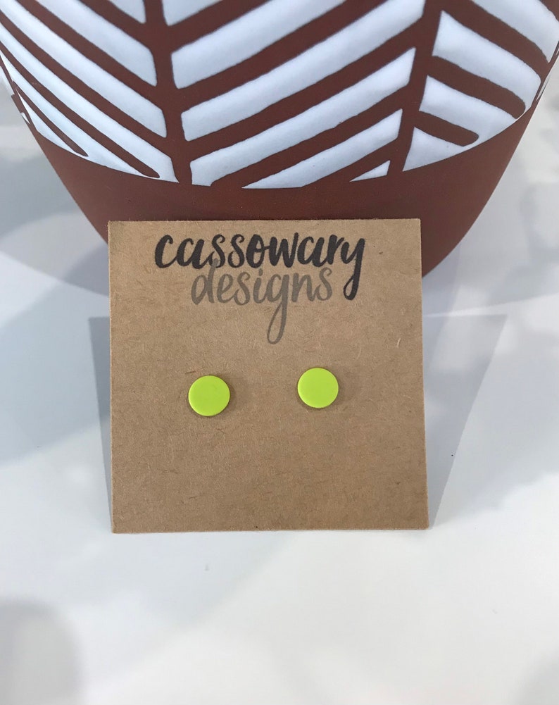 May include: A pair of neon green stud earrings on a brown card with the text "cassowary designs".