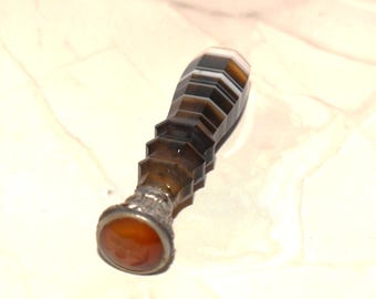 May include: A vintage wax seal with a brown and white banded agate handle and a round orange agate base.