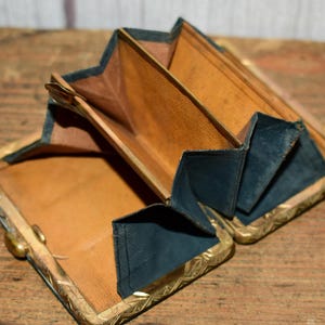 Könnte beinhalten: Eine weiße Keramik-Tasse mit schwarzem Henkel und dem Text "But First, Coffee" in fetter, schwarzer Schrift. Die Tasse steht vor einem verschwommenen Hintergrund, der eine gemütliche Umgebung suggeriert.