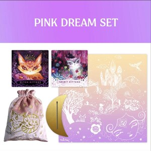 Może przedstawiać: Zestaw Pink Dream z ilustrowanymi kartami z kotami, woreczkiem ze sznurkiem ze złotym haftem i złotym stojakiem w kształcie p&oacute;łksiężyca. Karty przedstawiają projekty takie jak "Witch Kittens" i "Spirit Kittens". Zestaw ma motyw fantasy.