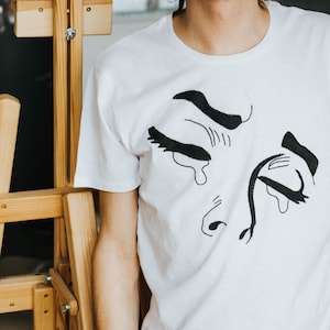T-shirt POP ART ricamata a mano con volto di donna triste che piange. Regalo perfetto, elegante e alla moda per lui, per lei o per te stesso.