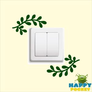 Peut inclure: Un interrupteur blanc à deux boutons, décoré de branches feuillues vertes sur un mur jaune clair.