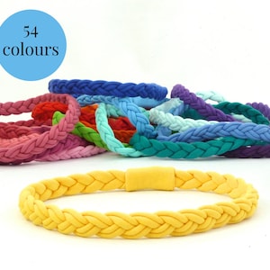 May include: A close-up of a yellow braided bracelet with a yellow plastic clasp. The bracelet is made of a soft, stretchy material. There are 54 different colours of these bracelets available.