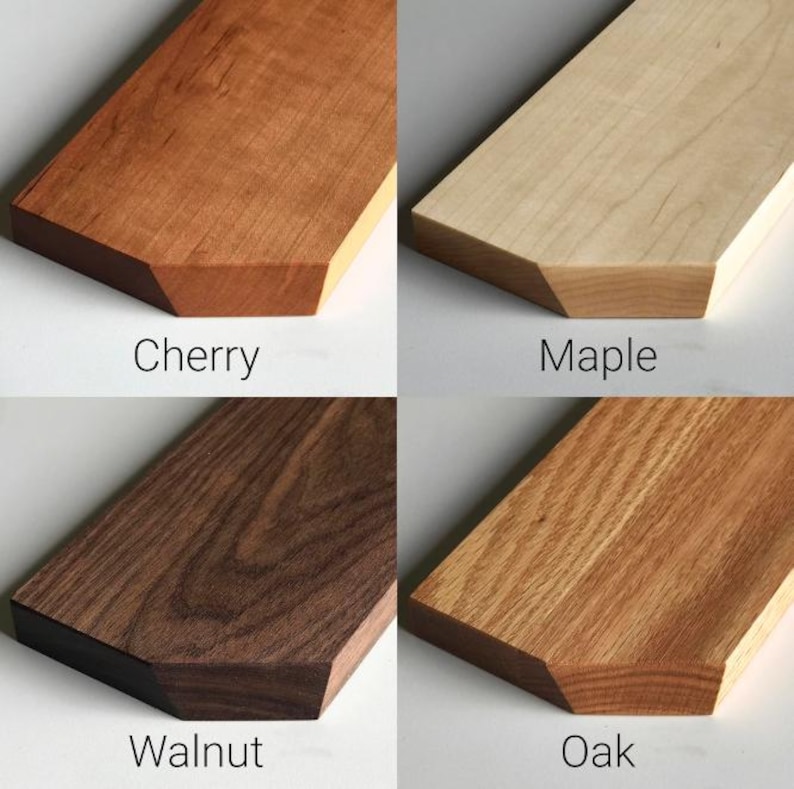 May include: Close-up of four wood samples: cherry, maple, walnut, and oak. Each sample is a rectangular piece of wood with a beveled edge.