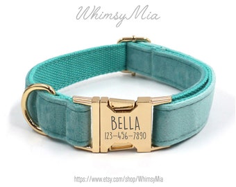 May include: A teal dog collar with a gold-colored buckle and hardware. The buckle is engraved with the name "BELLA" and a phone number. The collar is made of a soft, velvety material and features the text "WhimsyMia" in the upper left corner.