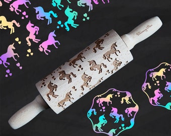Op de afbeelding: Een houten deegroller met gegraveerde eenhoornontwerpen en de tekst "Whimsy Mia" op de handgreep. De afbeelding bevat ook eenhoorn- en hartvormige uitsparingen in een regenboogkleurenschema, perfect voor bakken en knutselen.
