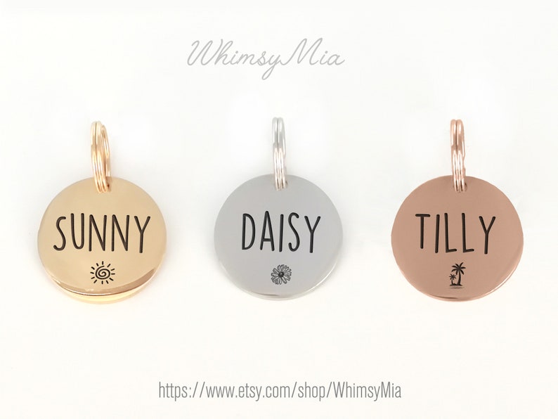May include: Three round pet tags in gold, silver, and rose gold. Each tag has a name in black text: "SUNNY", "DAISY", and "TILLY". Sunny has a sun graphic, Daisy a flower, and Tilly a palm tree.