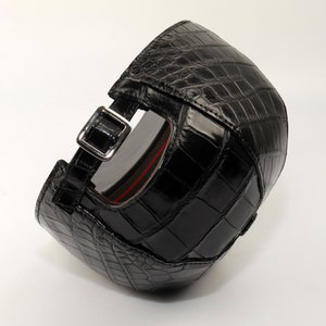 Back view of adjustable alligator cap with metal strap closure and detailed leather texture.