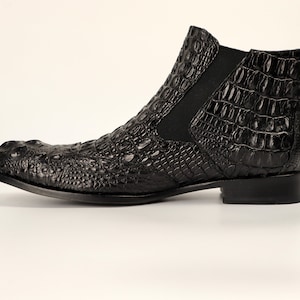 May include: Black leather ankle boots with a crocodile pattern.