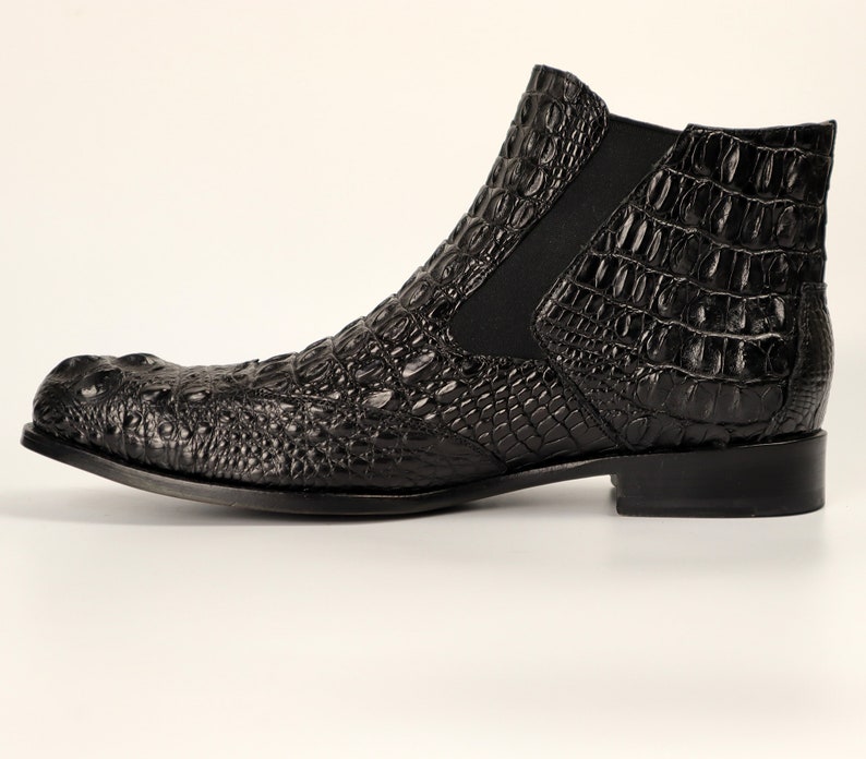 May include: Black leather ankle boots with a crocodile pattern.
