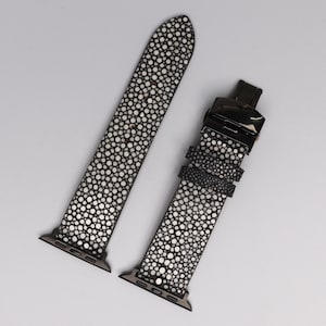 Handmade Apple Watch band crafted from stingray in black shagreen pattern. Exotic strap with soft cowhide leather lining and polished stainless steel clasp. Luxury replacement band fits all Apple Watch sizes, designed for men and women seeking unique, durable, and stylish accessories.