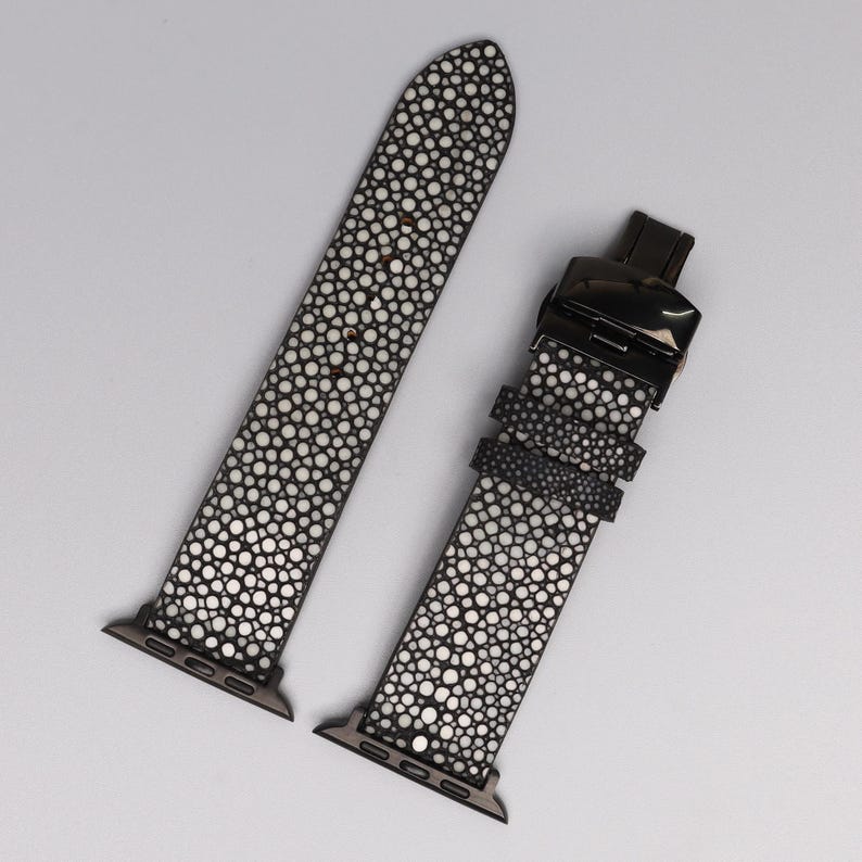 Handmade Apple Watch band crafted from stingray in black shagreen pattern. Exotic strap with soft cowhide leather lining and polished stainless steel clasp. Luxury replacement band fits all Apple Watch sizes, designed for men and women seeking unique, durable, and stylish accessories.