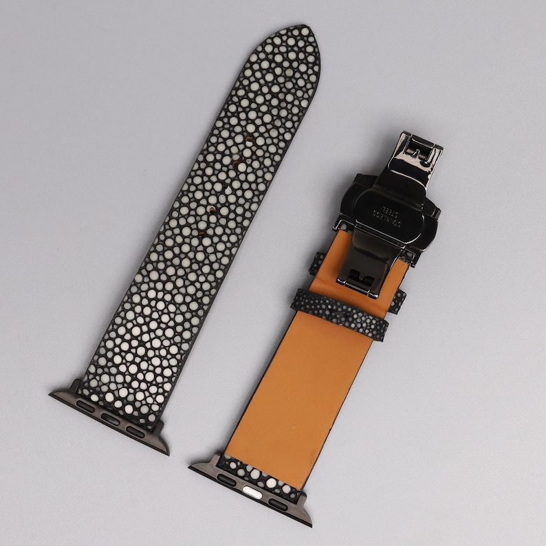 Puede incluir: Correa de reloj de dos piezas con un patr&oacute;n moteado en blanco y negro. La correa tiene un cierre negro y un interior marr&oacute;n claro. La correa est&aacute; dise&ntilde;ada para adaptarse a un reloj inteligente.