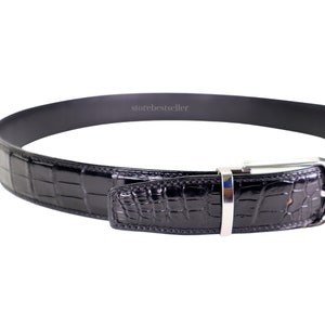 May include: Black alligator leather belt with a silver buckle. The belt is made of genuine alligator leather and has a classic design.