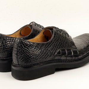 Rear view focusing on the heel structure, consistent scale texture wrapping around the back, and the transition between upper and sole.