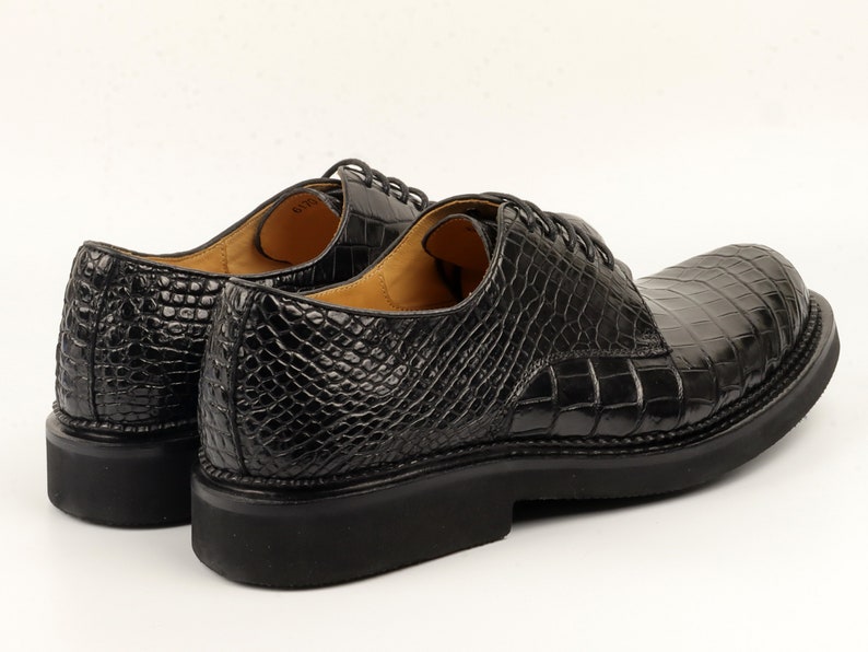 Rear view focusing on the heel structure, consistent scale texture wrapping around the back, and the transition between upper and sole.