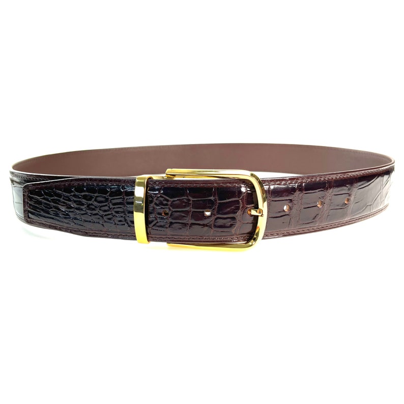 May include: A brown leather belt with a gold buckle. The belt has a crocodile pattern.