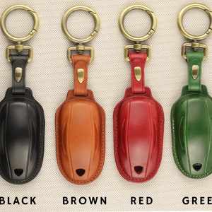May include: Four leather keychains in black, brown, red, and green. Each keychain has a gold metal ring and a leather loop.