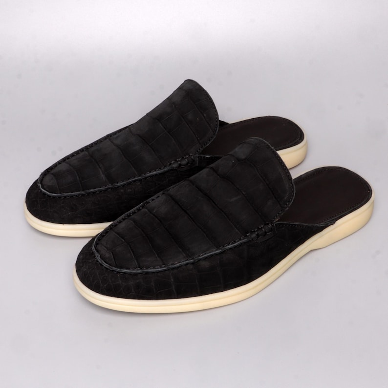 Handmade men’s mules crafted from genuine nubuck alligator leather in elegant matte black. Backless slip-on loafer style with moccasin-inspired stitching, soft cushioned leather insole, and durable rubber sole. Luxury exotic leather shoes designed for casual comfort, everyday wear, and refined style.