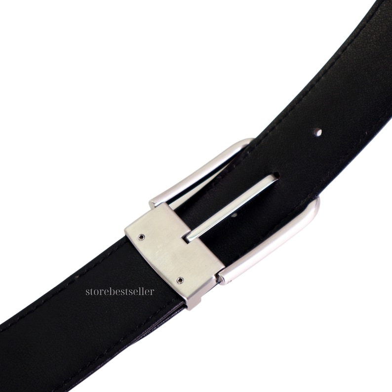May include: A black leather belt with a silver buckle. The buckle has a smooth, polished finish and a simple design.