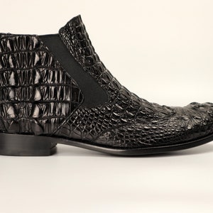 May include: Black leather ankle boots with a crocodile pattern.