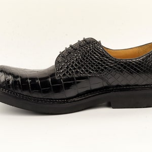 May include: Black leather lace-up shoes with a crocodile pattern.