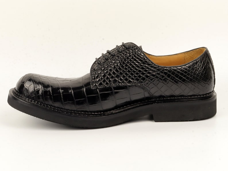 May include: Black leather lace-up shoes with a crocodile pattern.