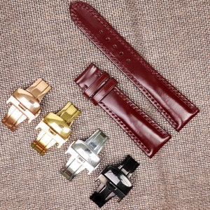 May include: Burgundy leather watch straps with contrasting stitching. Four watch clasps in gold, silver, and black are displayed. The watch straps are approximately 8 inches long.