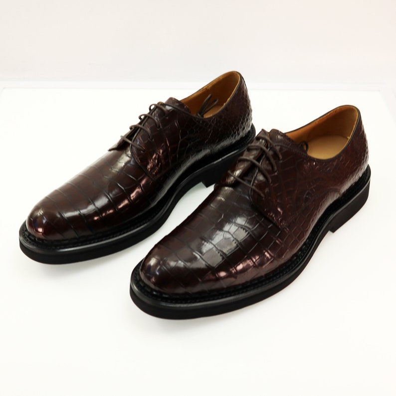 Top-down view revealing the symmetrical lace arrangement, uniform scale pattern across the vamp, and the shoe's overall streamlined shape.