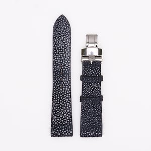 May include: A black leather watch strap with a silver buckle. The strap has a textured pattern.