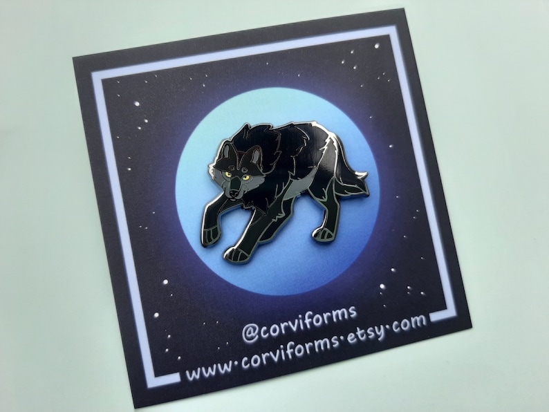 K&ouml;nnte beinhalten: Schwarze Emaille-Anstecknadel mit einem Wolf, der zum Mond heult. Die Anstecknadel ist vor einem blauen und schwarzen Sternenhimmel platziert. Die Anstecknadel tr&auml;gt den Text "@corviforms" und "www.corviforms.etsy.com".