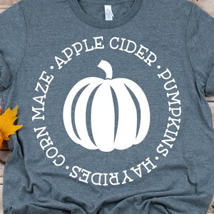 Może przedstawiać: Szara koszulka z białym nadrukiem dyni i tekstem "HAY RIDES. CORN MAZE. APPLE CIDER. PUMPKINS."