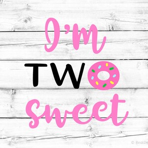 May include: Pink and black text on a white wood background reads "I'm Two Sweet" with a pink donut with colorful sprinkles in the middle.