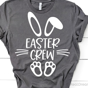 May include: Gray t-shirt with a white bunny ear design and the text "Easter Crew" with two white bunny footprints below.