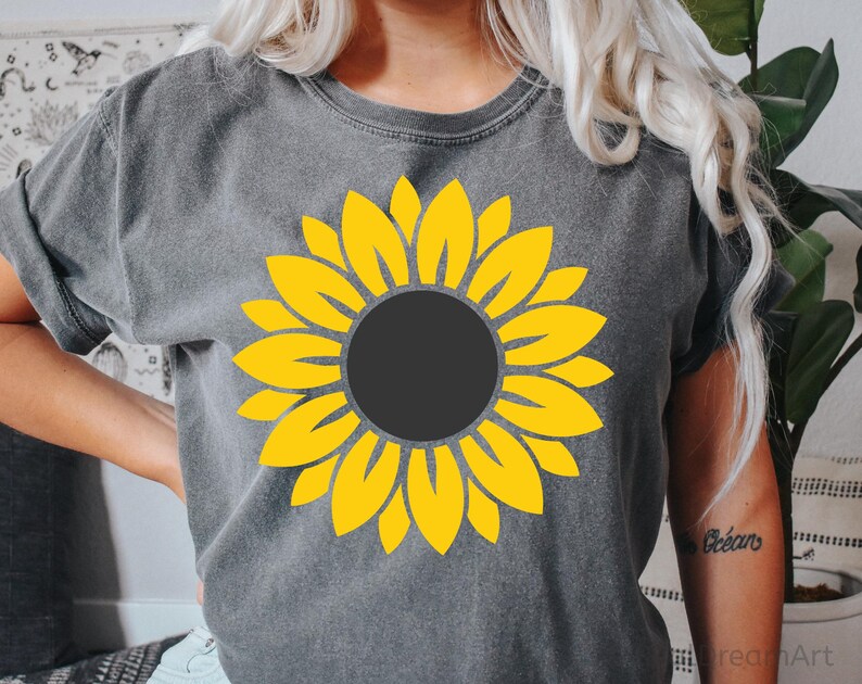 May include: A gray t-shirt with a yellow sunflower graphic. The sunflower has a dark gray center.