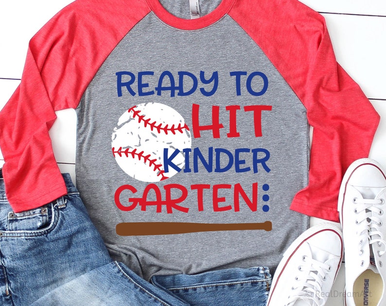 May include: A grey and red baseball-themed t-shirt with the text "Ready to Hit Kinder Garten:" and a baseball graphic.