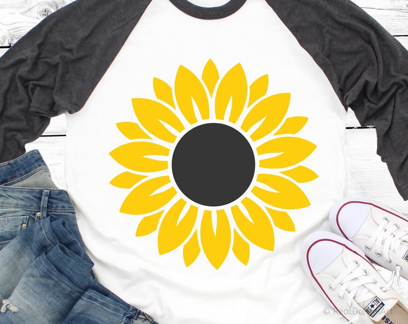 May include: A white t-shirt with a yellow sunflower graphic. The sunflower has a black center and yellow petals.