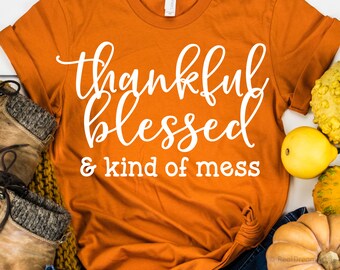 May include: Orange t-shirt with white text that reads "thankful blessed & kind of mess"