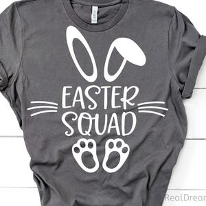 May include: A dark gray t-shirt with a white bunny rabbit design and the text "Easter Squad".
