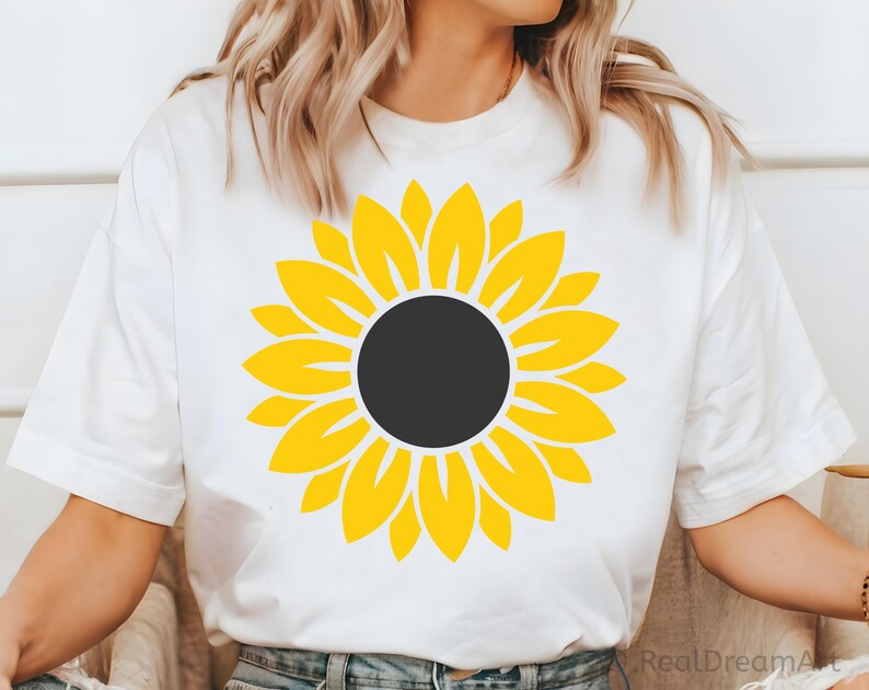 May include: White t-shirt with a yellow sunflower graphic.