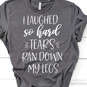 May include: Gray t-shirt with white text that reads "I laughed so hard tears ran down my legs".