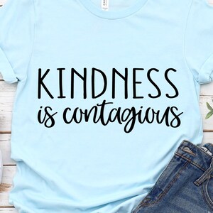 May include: Light blue t-shirt with the text "Kindness is contagious" in black lettering.