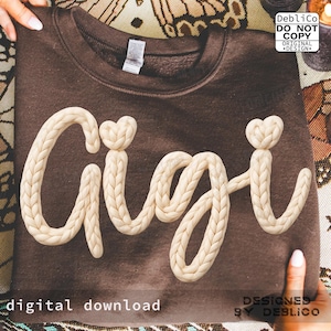 May include: A brown sweatshirt with the name "Gigi" in a cream-colored, braided font. The word "Gigi" has a heart-shaped detail above the second "i". The words "digital download" and "designed by Deblico" are also visible.