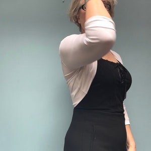 Bolero lightweight jacket, 3/4 sleeves, perfect over sleeveless dresses for arm coverage and shoulder  warmth. Colours come in black, white and navy, in sizes small, medium, large and Xlarge. Easily stored in a clutch bag, when not being worn.