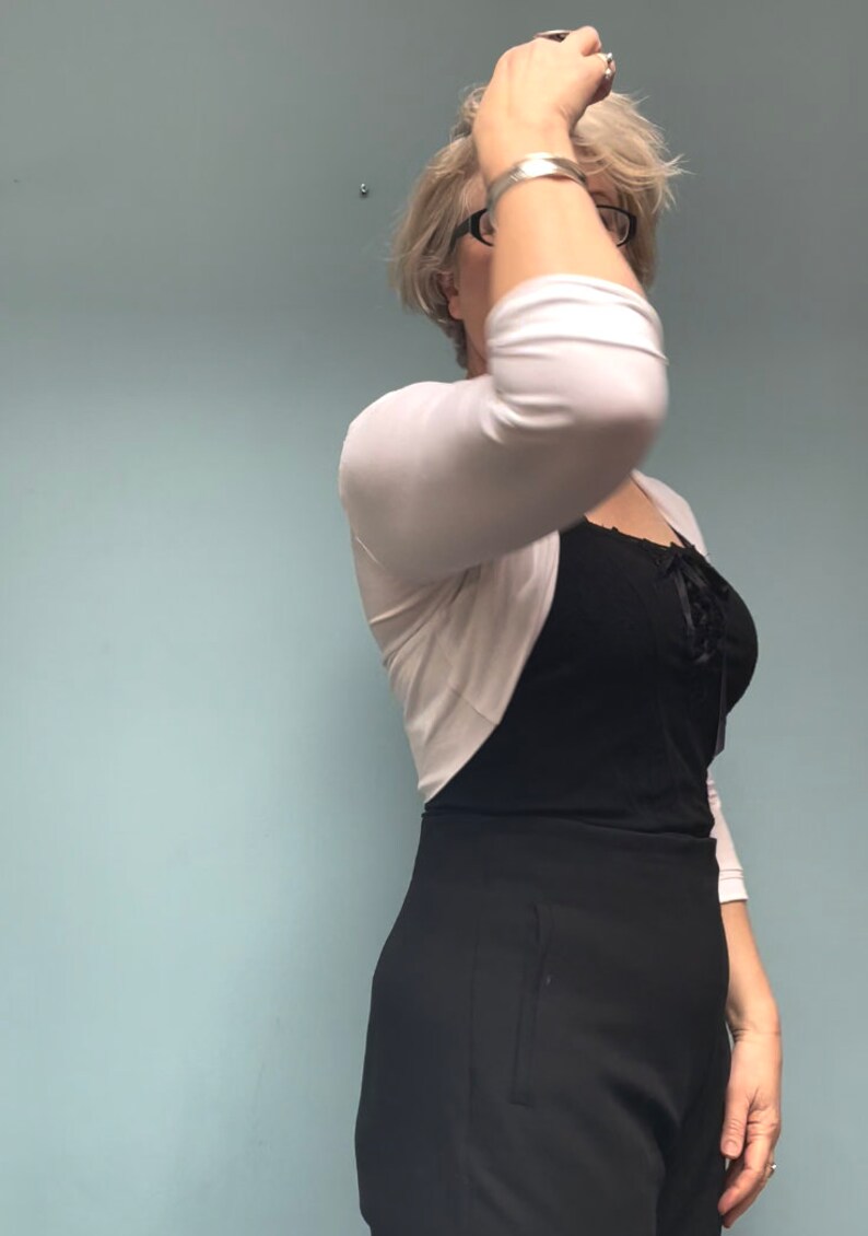 Bolero lightweight jacket, 3/4 sleeves, perfect over sleeveless dresses for arm coverage and shoulder  warmth. Colours come in black, white and navy, in sizes small, medium, large and Xlarge. Easily stored in a clutch bag, when not being worn.